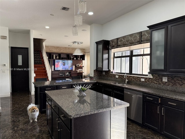 kitchen featuring stainless steel dishwasher, visible vents, a sink, and dark cabinets
