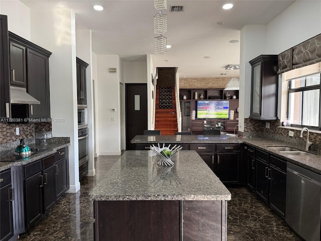 kitchen with tasteful backsplash, a center island, appliances with stainless steel finishes, marble finish floor, and a sink