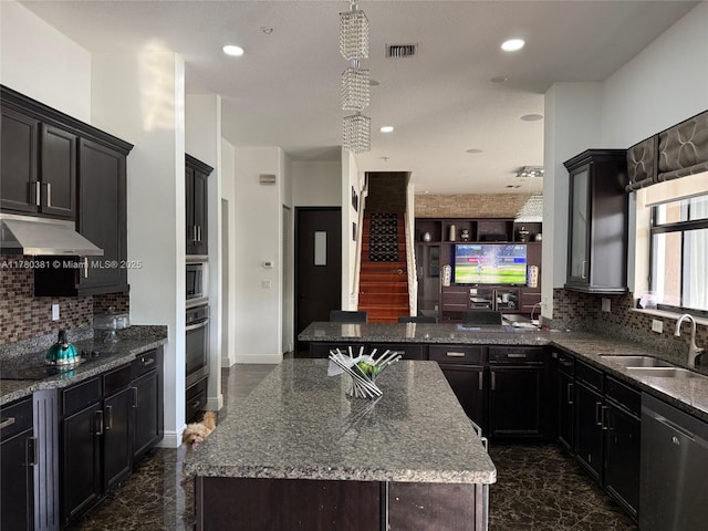 kitchen with under cabinet range hood, visible vents, stainless steel appliances, marble finish floor, and a sink