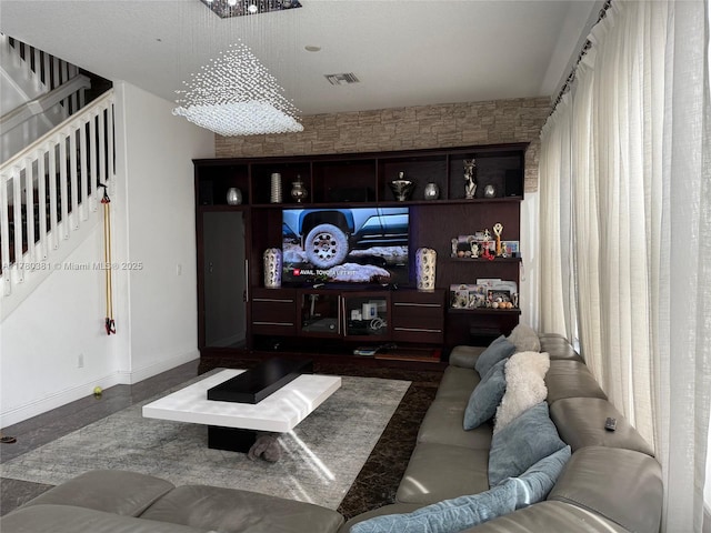 living area with baseboards, visible vents, and stairs
