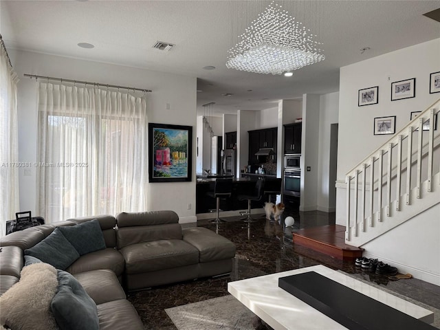 living room featuring a textured ceiling, baseboards, visible vents, and stairs