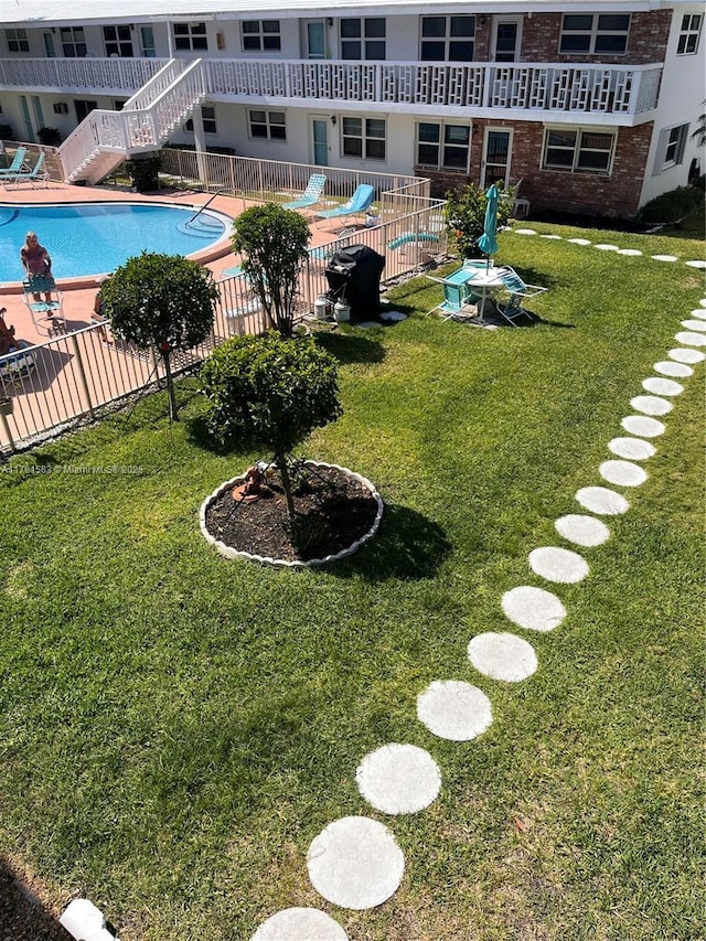 view of yard featuring a community pool, fence, and a patio area
