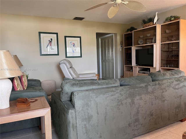 tiled living room with ceiling fan and visible vents