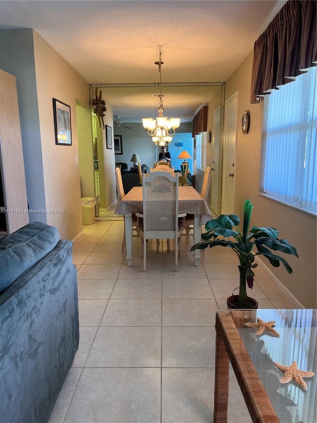 dining space featuring light tile patterned floors, baseboards, and a textured ceiling