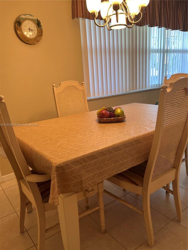 tiled dining room featuring a chandelier