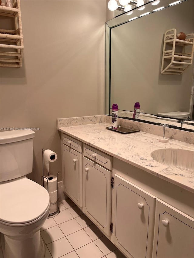 half bathroom with tile patterned floors, vanity, and toilet
