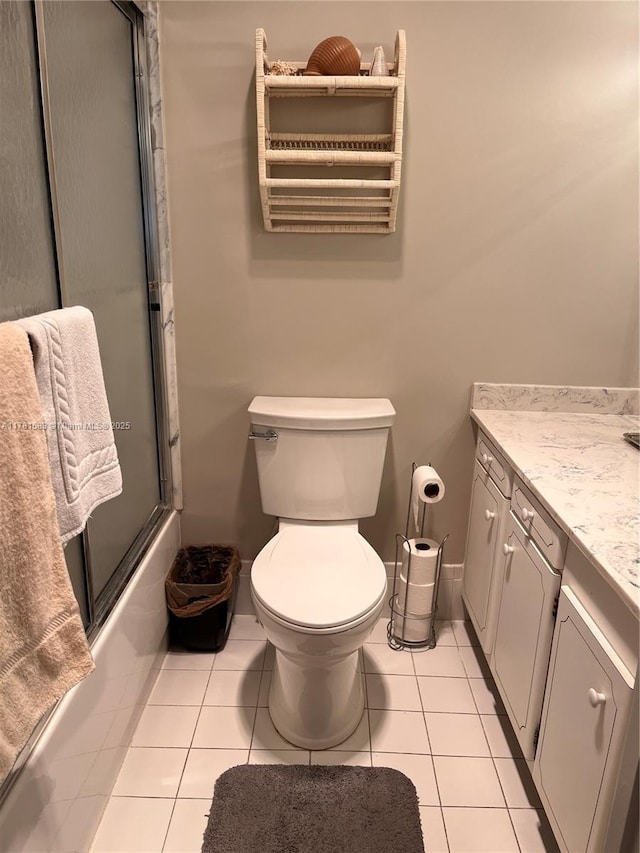 full bath featuring toilet, tile patterned floors, vanity, and enclosed tub / shower combo