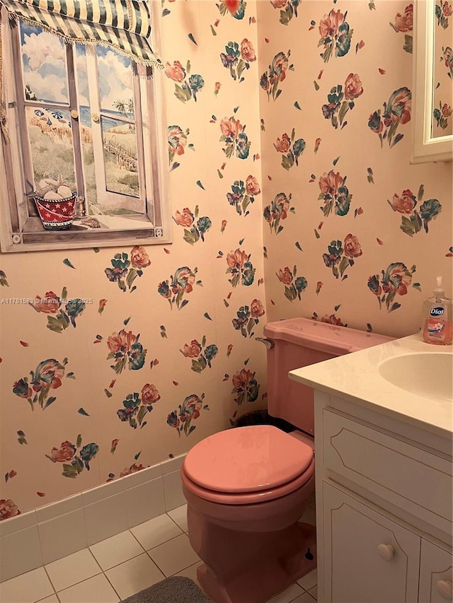 half bathroom with vanity, tile patterned flooring, and wallpapered walls