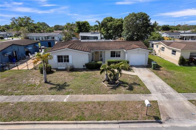 view of front of house featuring stucco siding, a tile roof, an attached garage, driveway, and a residential view