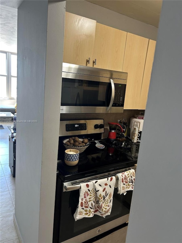 2899 Collins Ave Unit 708, Miami Beach, FL 33140 - kitchen with stainless steel appliances, light brown cabinets, and light tile patterned floors