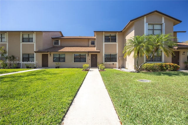 view of front of house with a front yard and stucco siding