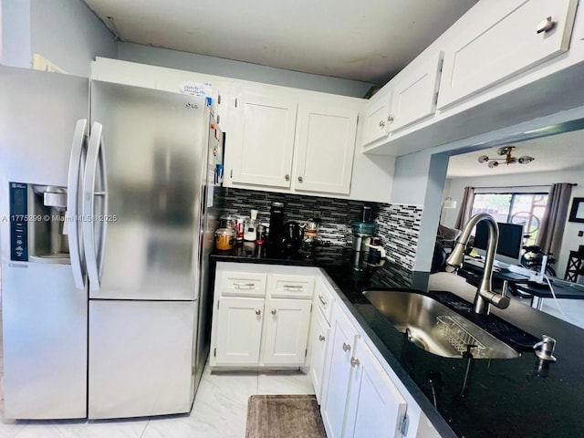 kitchen with white cabinets, stainless steel refrigerator with ice dispenser, marble finish floor, a sink, and backsplash