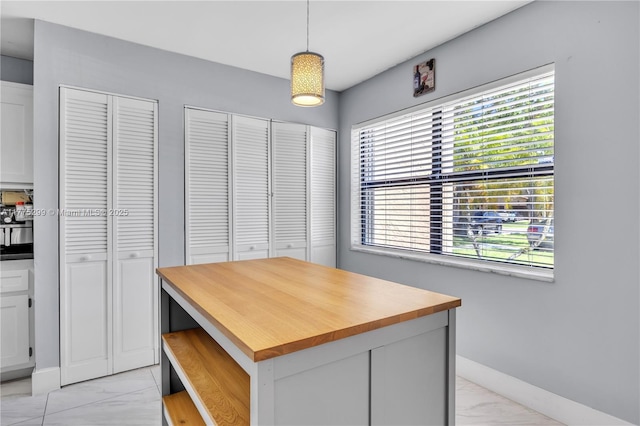 interior space with baseboards, marble finish floor, and plenty of natural light