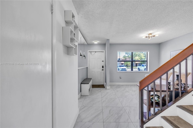 interior space featuring baseboards, a textured ceiling, marble finish floor, and stairs