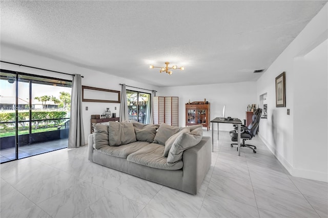 living room featuring marble finish floor, a notable chandelier, and a textured ceiling