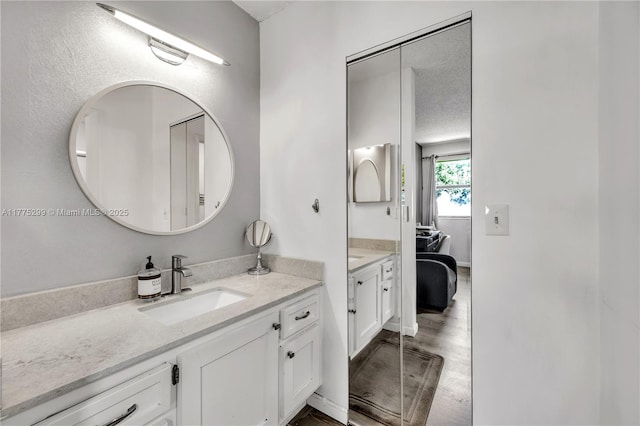 bathroom featuring connected bathroom, vanity, and wood finished floors