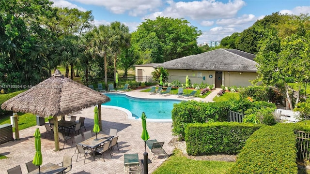 community pool with a patio and fence
