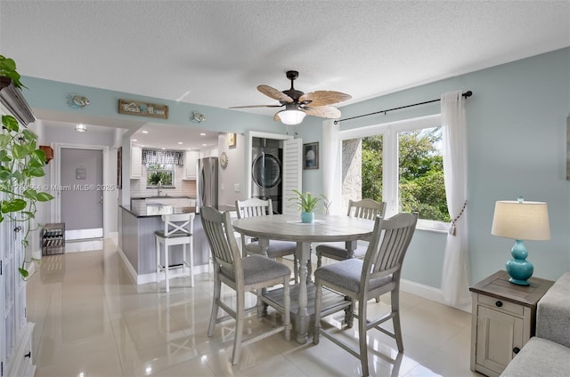 dining area featuring light tile patterned floors, baseboards, a textured ceiling, and ceiling fan
