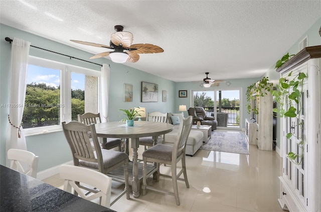 dining area with a water view, a textured ceiling, a ceiling fan, and light tile patterned flooring