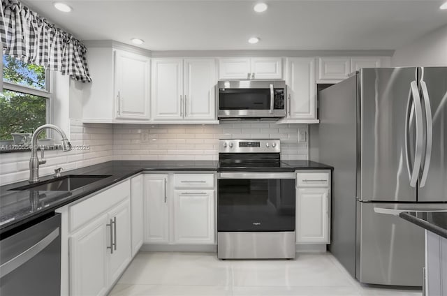 kitchen featuring white cabinetry, recessed lighting, a sink, stainless steel appliances, and backsplash