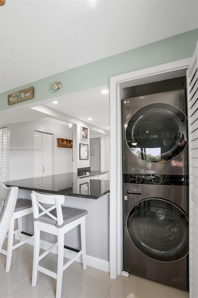 washroom featuring tile patterned floors, laundry area, recessed lighting, and stacked washer / drying machine