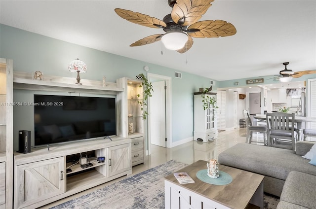 living area with visible vents, baseboards, and a ceiling fan