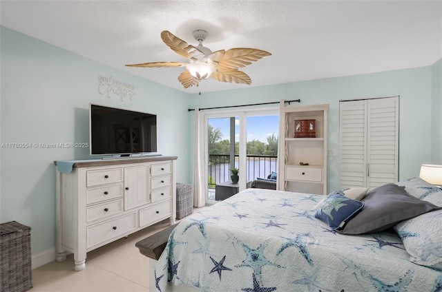 bedroom featuring a closet, baseboards, tile patterned floors, access to exterior, and ceiling fan