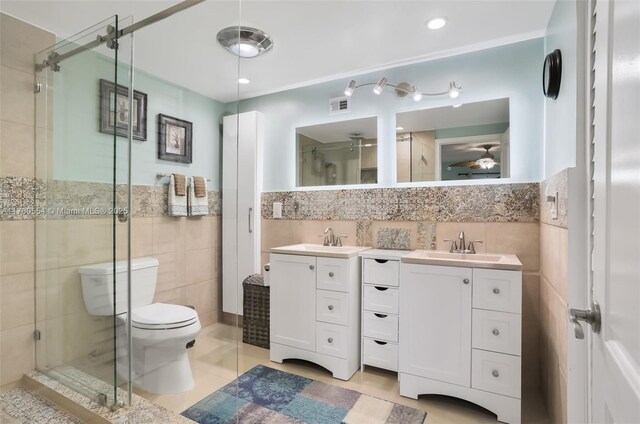 full bathroom with vanity, tile patterned floors, a shower stall, visible vents, and tile walls