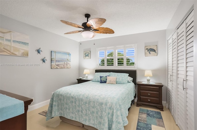 bedroom featuring a textured ceiling, a closet, baseboards, and a ceiling fan