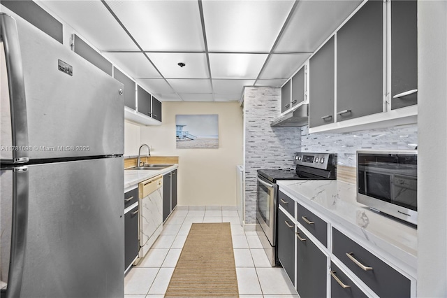 kitchen featuring tasteful backsplash, light tile patterned floors, extractor fan, stainless steel appliances, and a sink