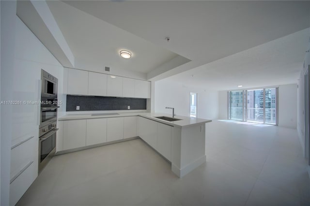 300 Sunny Isles Blvd Unit 4-1904, Sunny Isles Beach, FL 33160 - kitchen featuring modern cabinets, a sink, open floor plan, white cabinetry, and tasteful backsplash