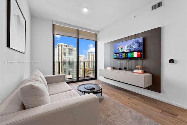 398 NE 5th St Unit 2119, Miami, FL 33132 - living room featuring wood finished floors, visible vents, baseboards, and a wall of windows