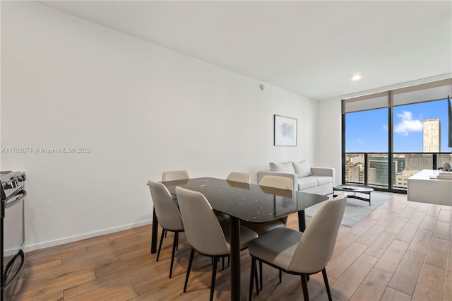 398 NE 5th St Unit 2119, Miami, FL 33132 - dining space featuring expansive windows, light wood-type flooring, and baseboards