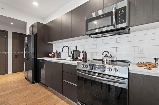 398 NE 5th St Unit 2119, Miami, FL 33132 - kitchen with a sink, light countertops, black appliances, and light wood finished floors