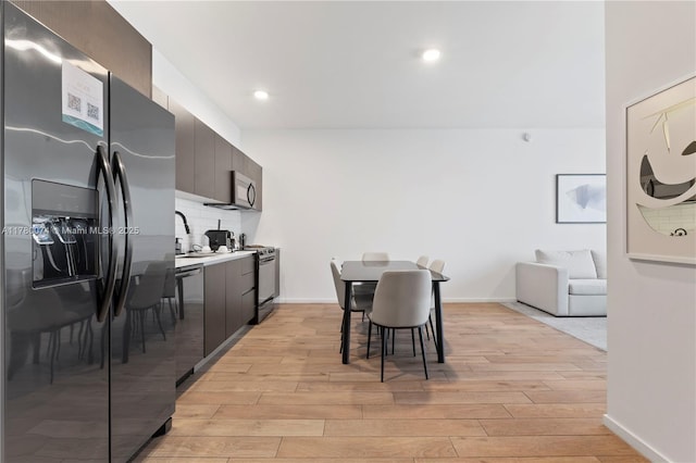 398 NE 5th St Unit 2119, Miami, FL 33132 - kitchen featuring light wood-style floors, modern cabinets, tasteful backsplash, a sink, and stainless steel appliances