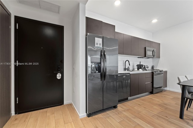 398 NE 5th St Unit 2119, Miami, FL 33132 - kitchen with dishwashing machine, light wood-style flooring, stainless steel microwave, black fridge with ice dispenser, and electric range oven