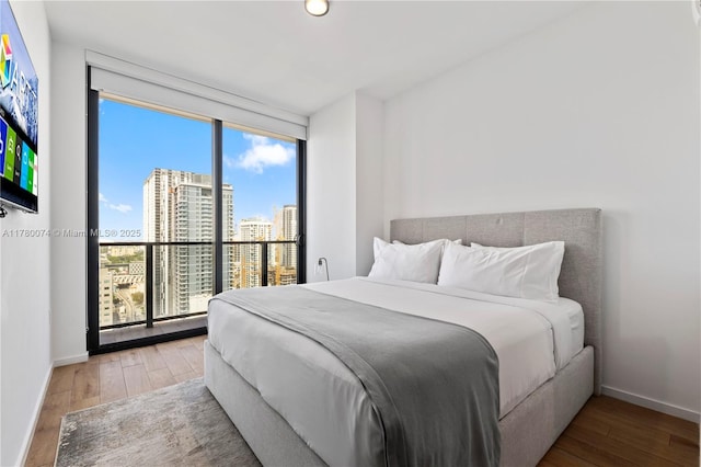 398 NE 5th St Unit 2119, Miami, FL 33132 - bedroom featuring a city view, wood-type flooring, and baseboards