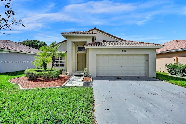 mediterranean / spanish-style house with a front yard, stucco siding, concrete driveway, an attached garage, and a tile roof