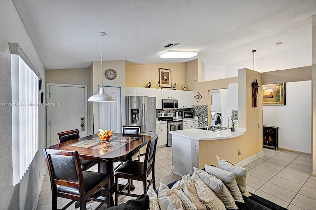 kitchen featuring visible vents, tasteful backsplash, light tile patterned floors, stainless steel appliances, and white cabinetry