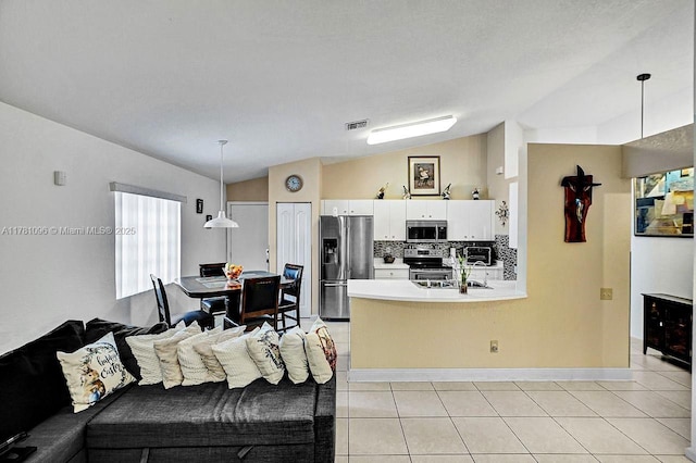living room featuring visible vents, baseboards, light tile patterned floors, and lofted ceiling
