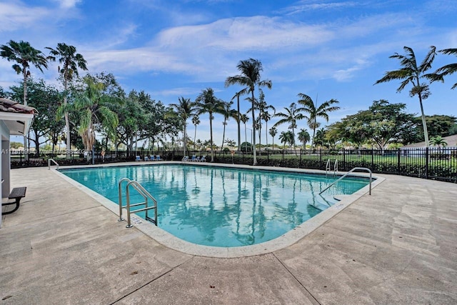 community pool with fence and a patio area