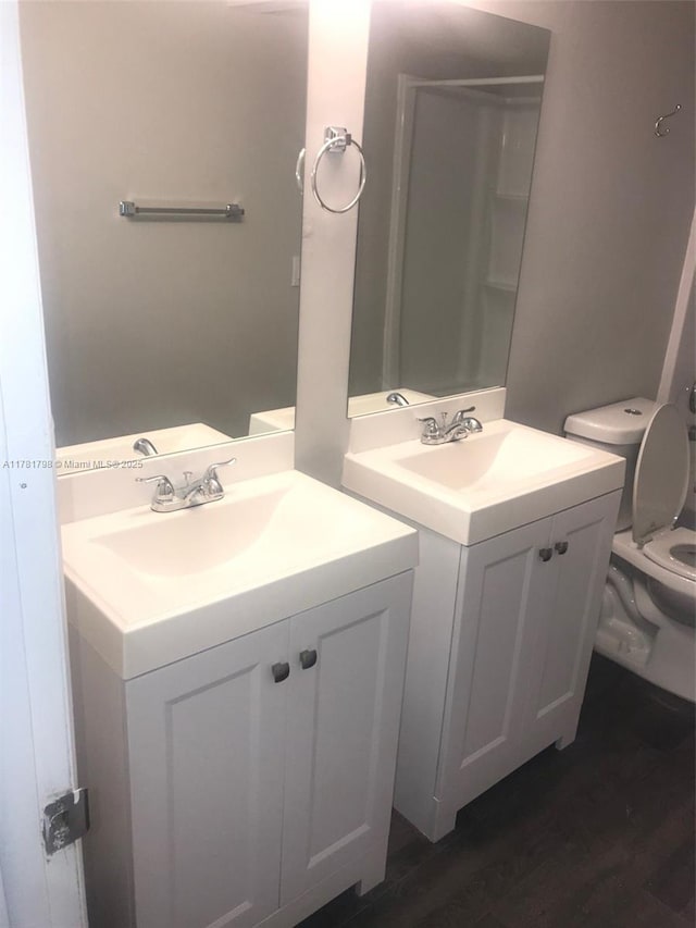 full bath with toilet, wood finished floors, and vanity