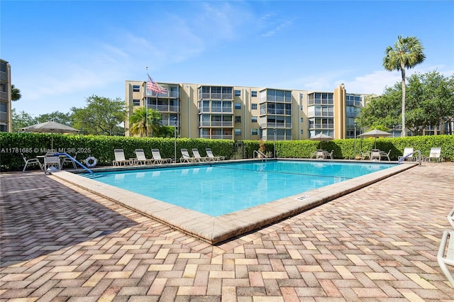 pool with a patio area and fence