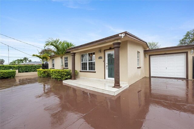 ranch-style home with concrete driveway, stucco siding, and an attached garage