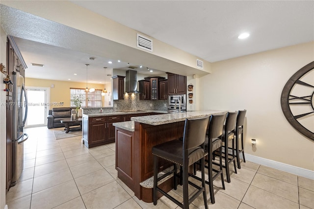 kitchen featuring visible vents, dark brown cabinetry, a peninsula, and stainless steel appliances