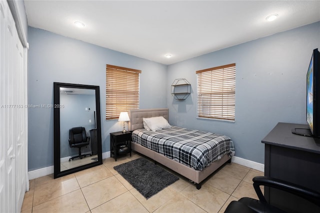 bedroom with light tile patterned flooring and baseboards