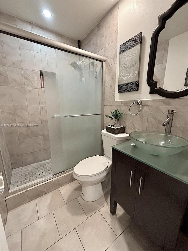 bathroom featuring vanity, recessed lighting, toilet, tile walls, and a stall shower