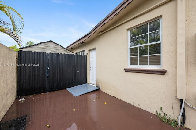 view of home's exterior featuring stucco siding and fence