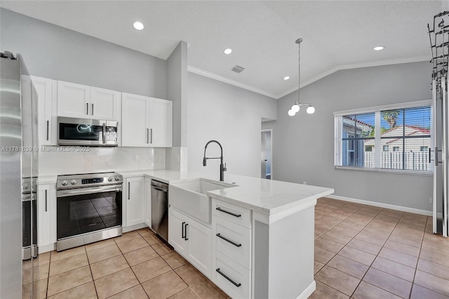 kitchen featuring a peninsula, light tile patterned flooring, a sink, lofted ceiling, and stainless steel appliances