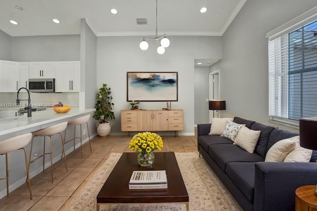 living room with crown molding, visible vents, baseboards, and light tile patterned flooring